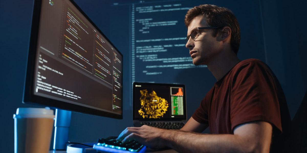 Desenvolvedor concentrado trabalhando em um ambiente escuro com múltiplas telas exibindo códigos de programação e gráficos analíticos. Ele usa óculos e está digitando em um teclado, com uma xícara de café ao lado, representando dedicação e foco em projetos de tecnologia. (python, cargos, segurança)